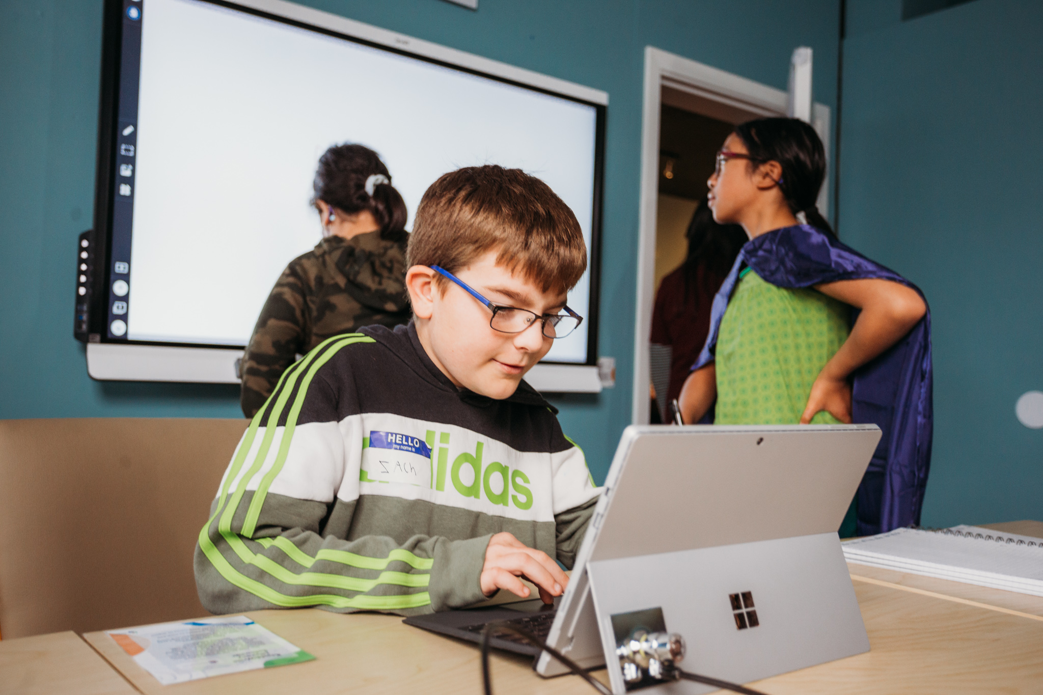 https://lightwelllearning.ca/wp-content/uploads/2022/11/Male-student-sitting-at-laptop-while-two-students-are-at-Smartboard-in-background.jpg