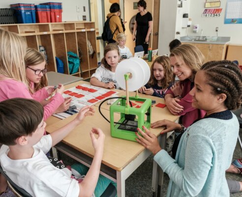Classroom full of students learning together with an experiment