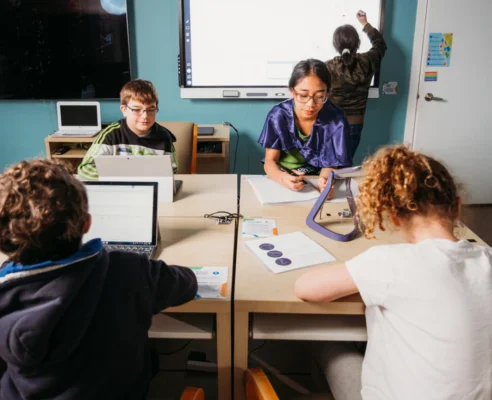 A small group of young students learning and working on projects