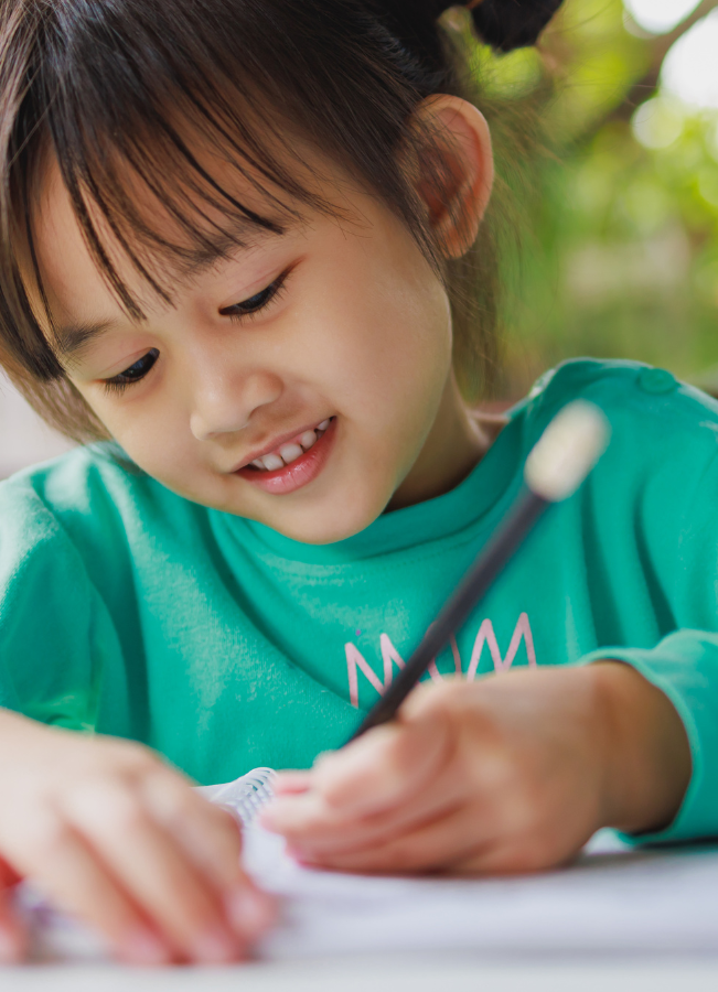 https://lightwelllearning.ca/wp-content/uploads/2022/12/Smiling-Kid-Writing.png