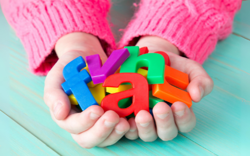 child holding colourful letters