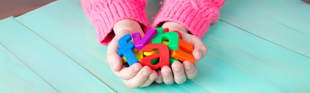 child holding colourful letters