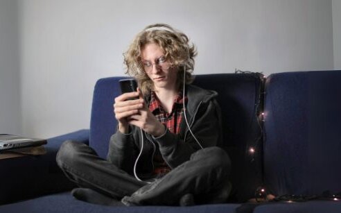 teen on soft looking at phone