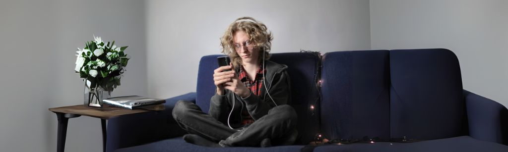 teen on soft looking at phone