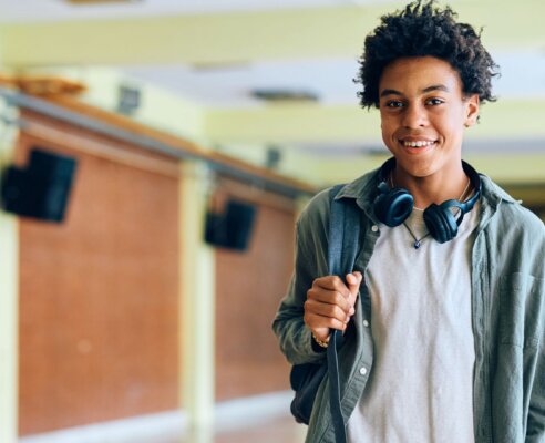 high school boy looking at camera in school hallway