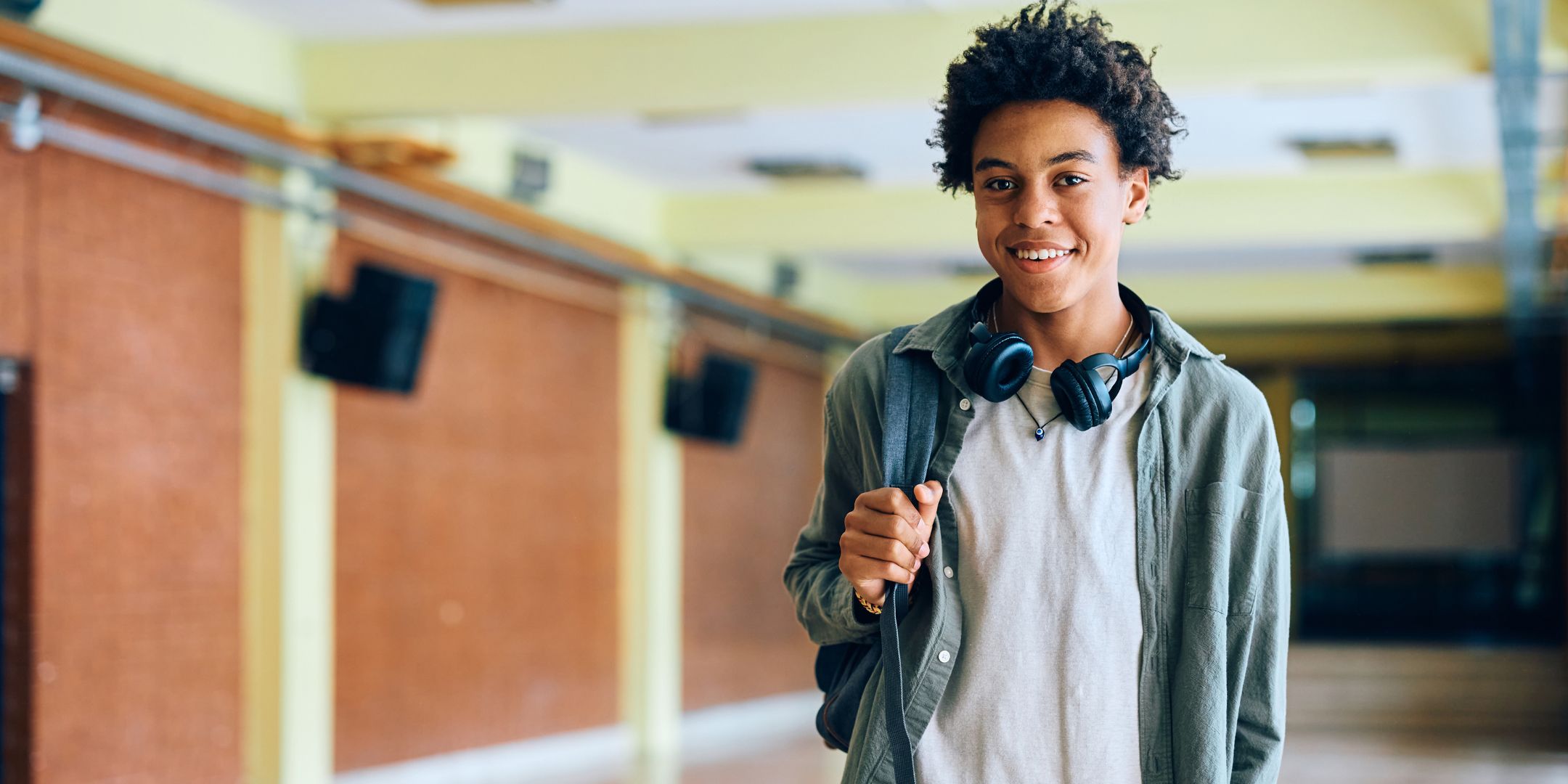 high school boy looking at camera in school hallway