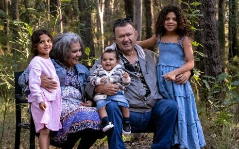 Family posing for photo in forest