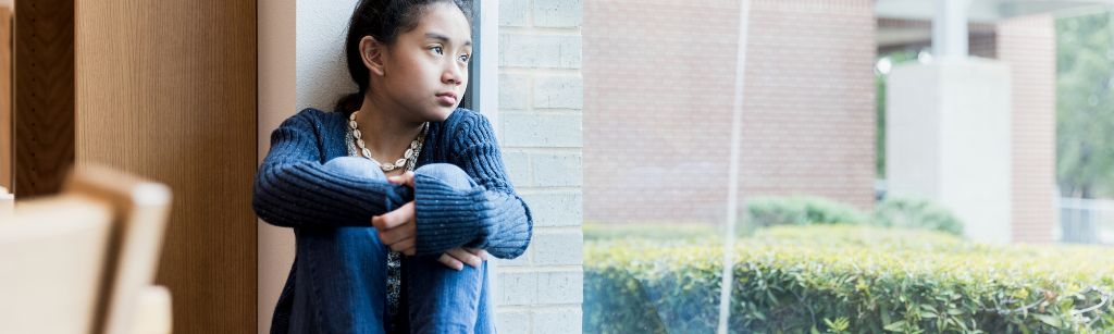 girl looking out window, sad