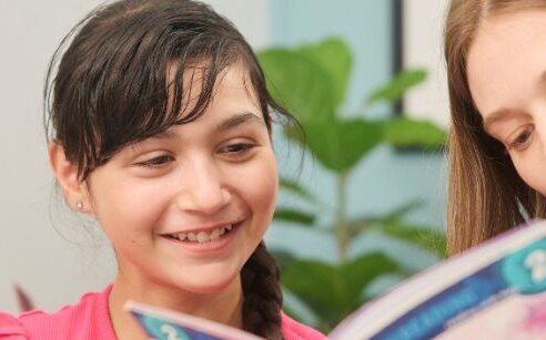 Girl and instructor reading a book together