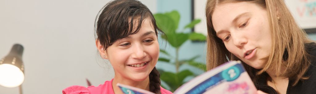 Girl and instructor reading a book together
