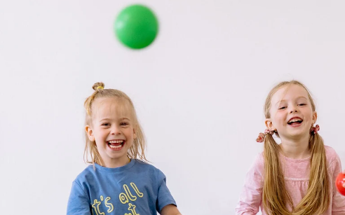 Happy kids playing with colourful balls.